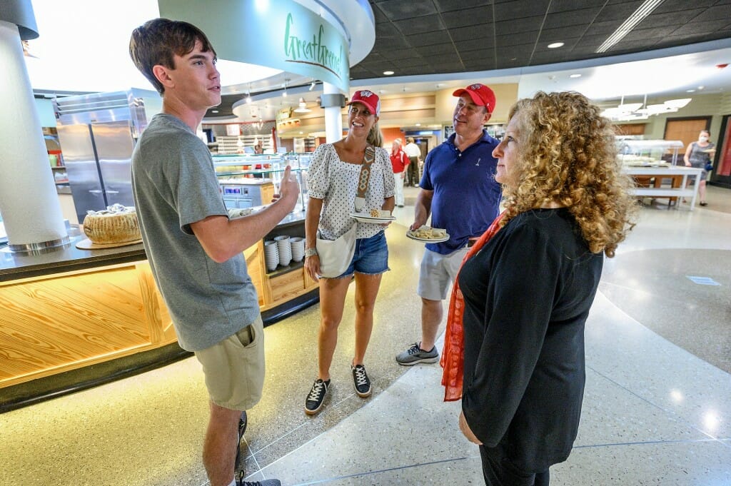 At right, Chancellor Mnookin greets first-year student Will Hicks from Charlotte, N.C., and his parents, as they grab a bite to eat in the Dejope Residence Hall during move-in day.