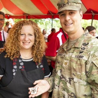 Chancellor Mnookin talks with a man wearing a camouflage uniform.