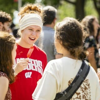 A group of students gather in the sunshine to eat ice cream and popsicles, and to talk.