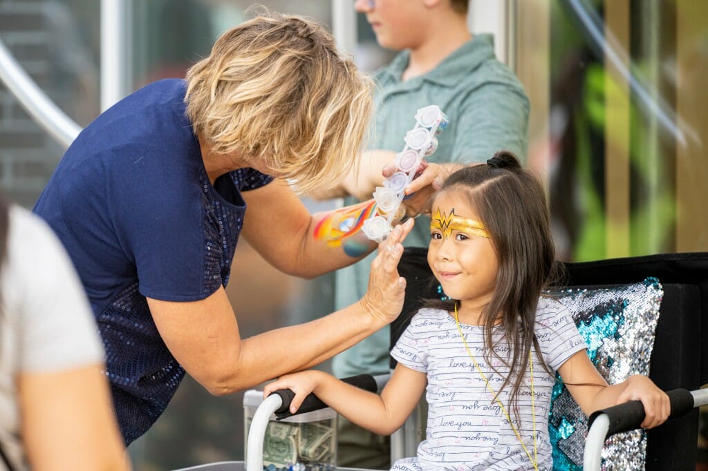 An artist paints on a girl's face.