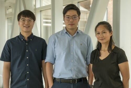 Three people stand in a large lobby.