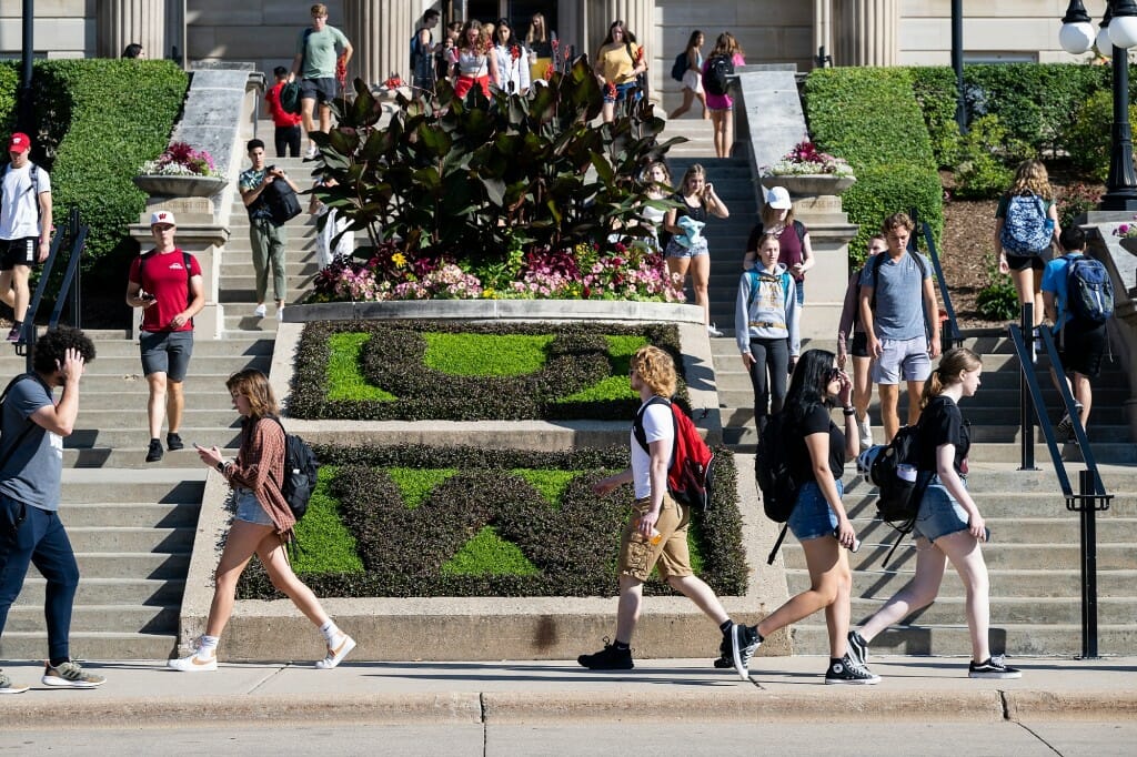 Students walk various directions on a staircase.