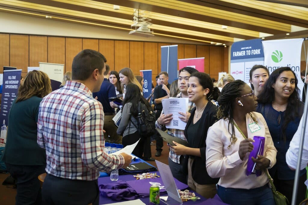 A student shakes the hand of a recruiter.