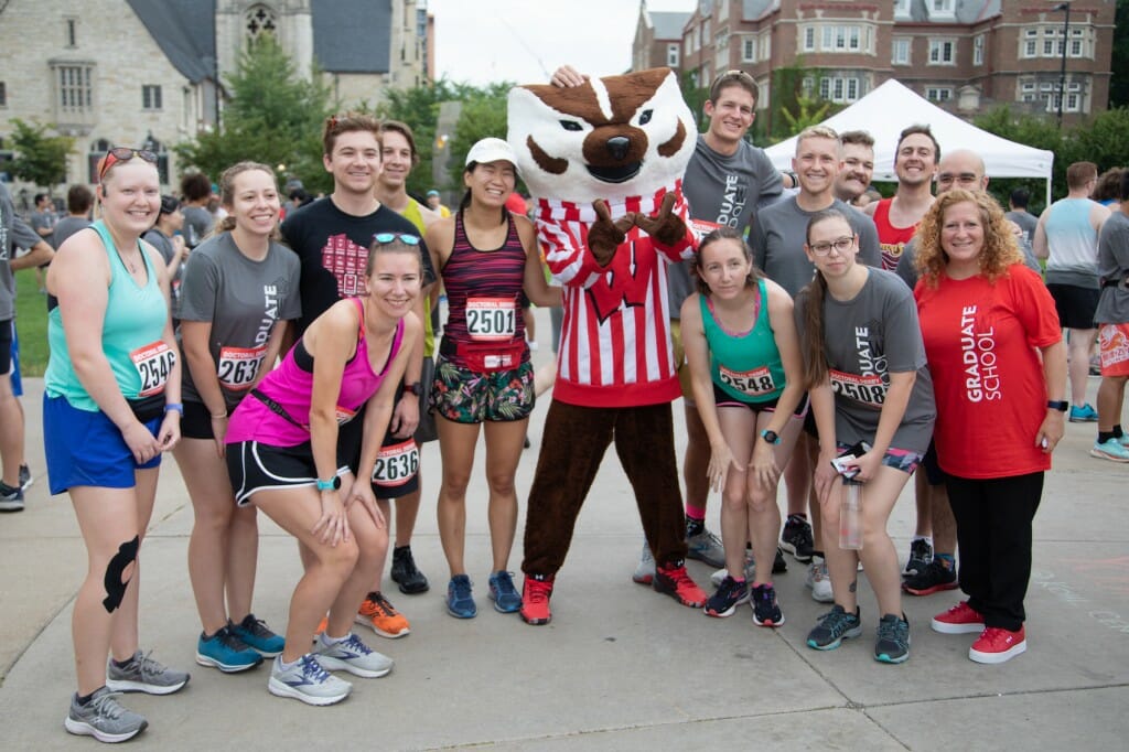 A group of people stand together and smile at the camera.