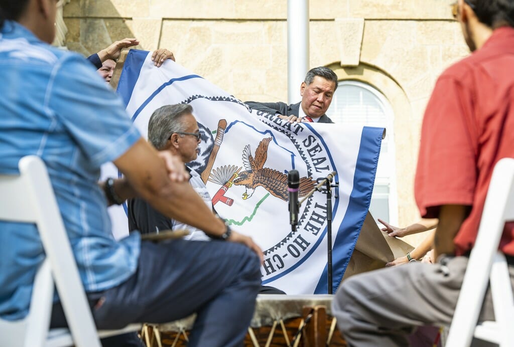 A man unfurls a flag.