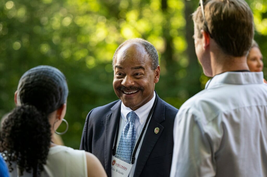 A man talks to two other people.