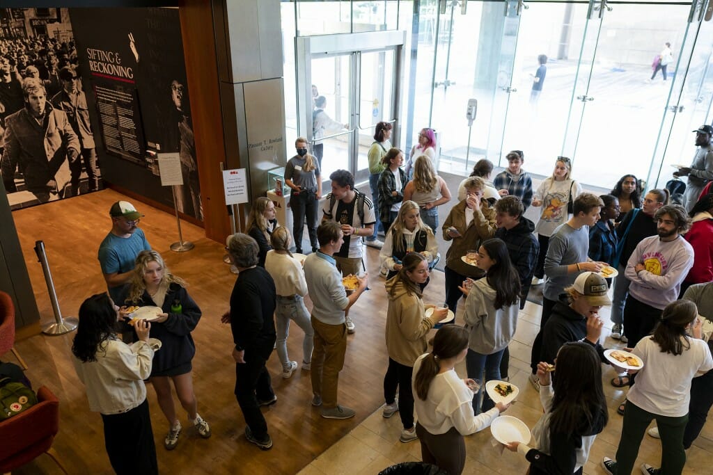 A view from above: People mill about and snack in a big open room at the Chazen.