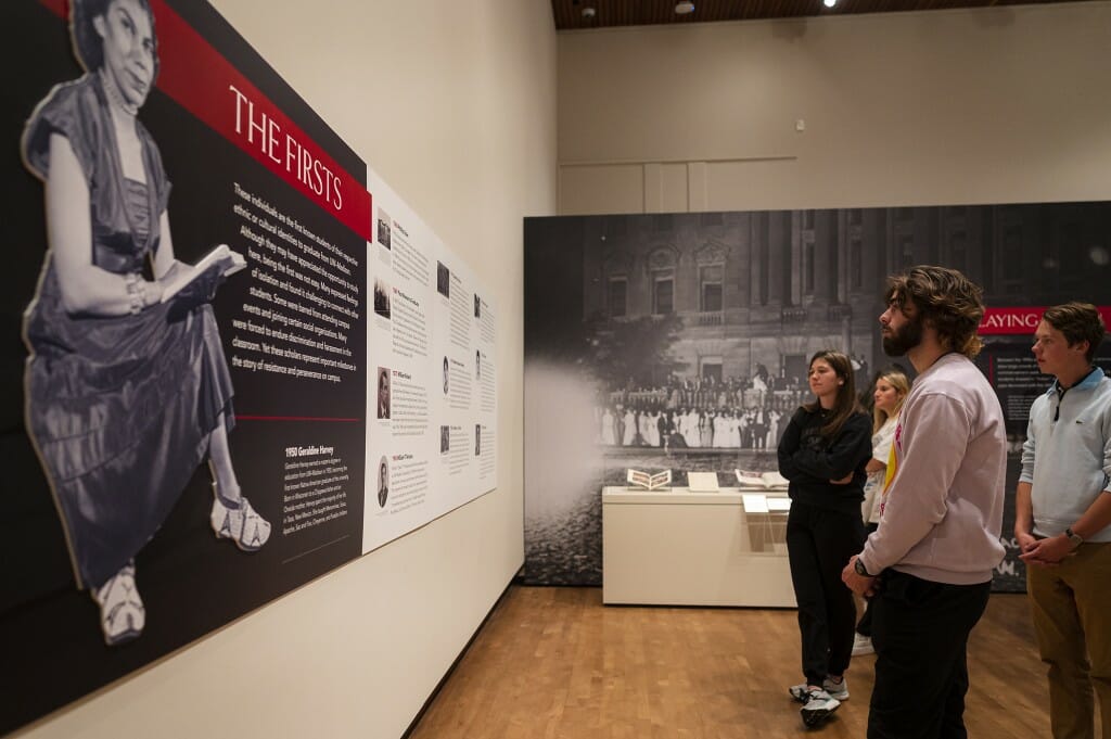 People look at an exhibit on the wall at the museum.