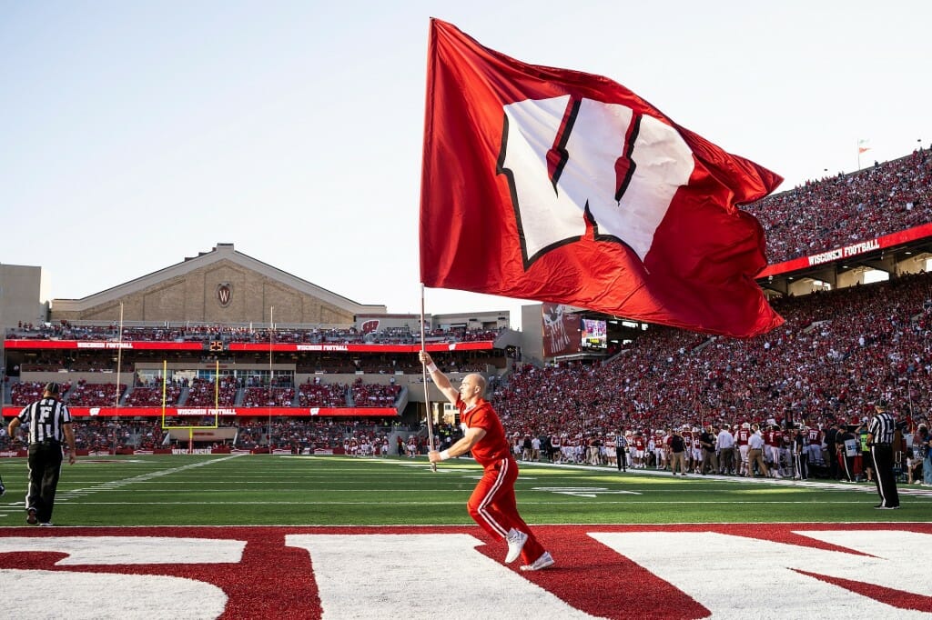 A UW cheerleader waves a giant W flag to rev up the crowd following a touchdown.