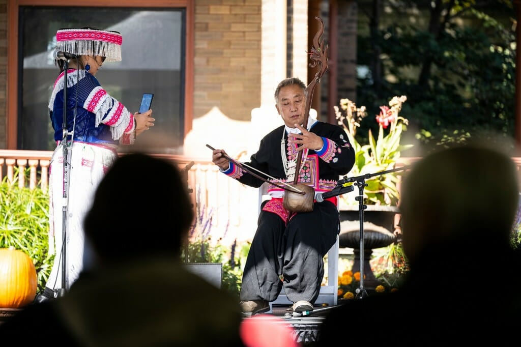 Musician Wa Cha Xiong plays the two-string violin (Nkauj Laug Ncas) as part of a Hmong storytelling performance during the Harvest Folk Festival at the Allen Centennial Garden.