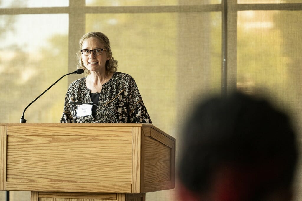 Lauren Papp stands at a podium speaking to an unseen audience.