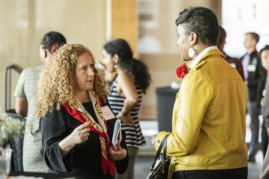 Jennifer Mnookin (left) speaks with Angela Byars-Winston in a brightly sunlit room.