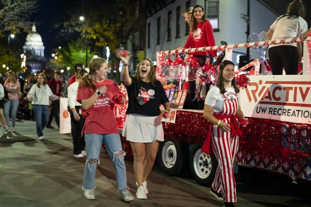 A group of people laughs and talks in front of a float.