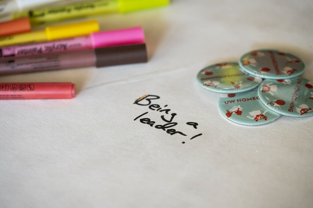 A close up of colorful markers and a white canvas.