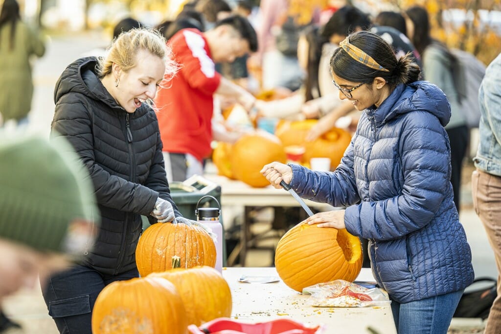 Students Sophia Schaubel (left) and Khadijah Dhoondia (right) delight in their pumpkin artistry.