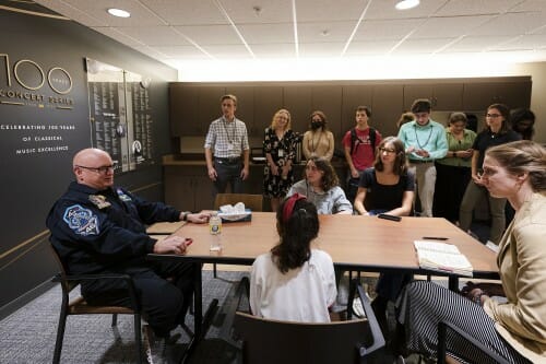 Seated around a long table, students ask Scott Kelly questions.