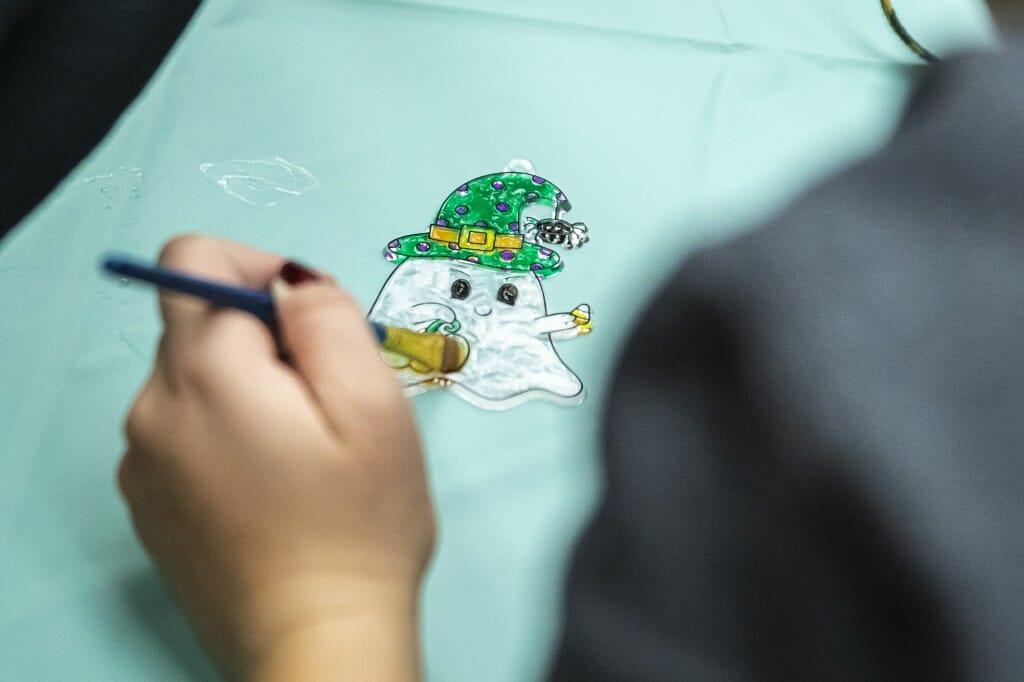 A close-up of a ghost suncatcher being painted.