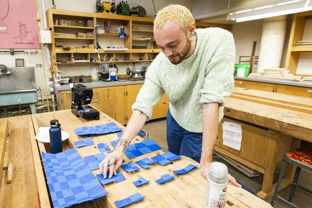 A man works on a quilt.