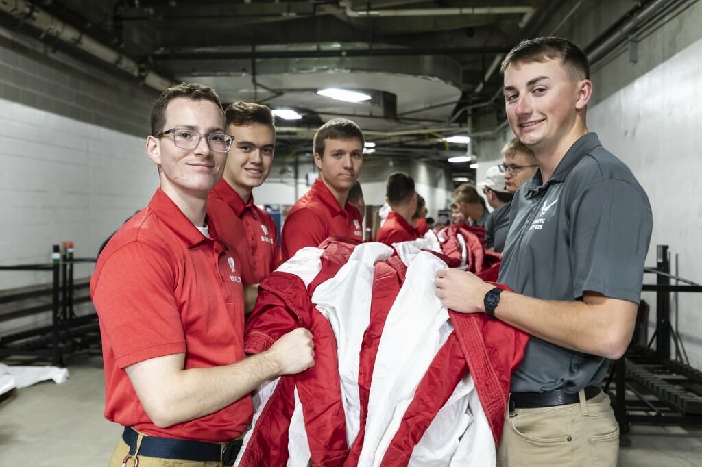 A group of men hold an American flag.