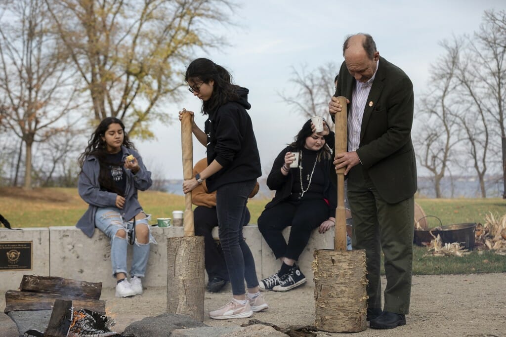 Participants learn how to grind corn. 