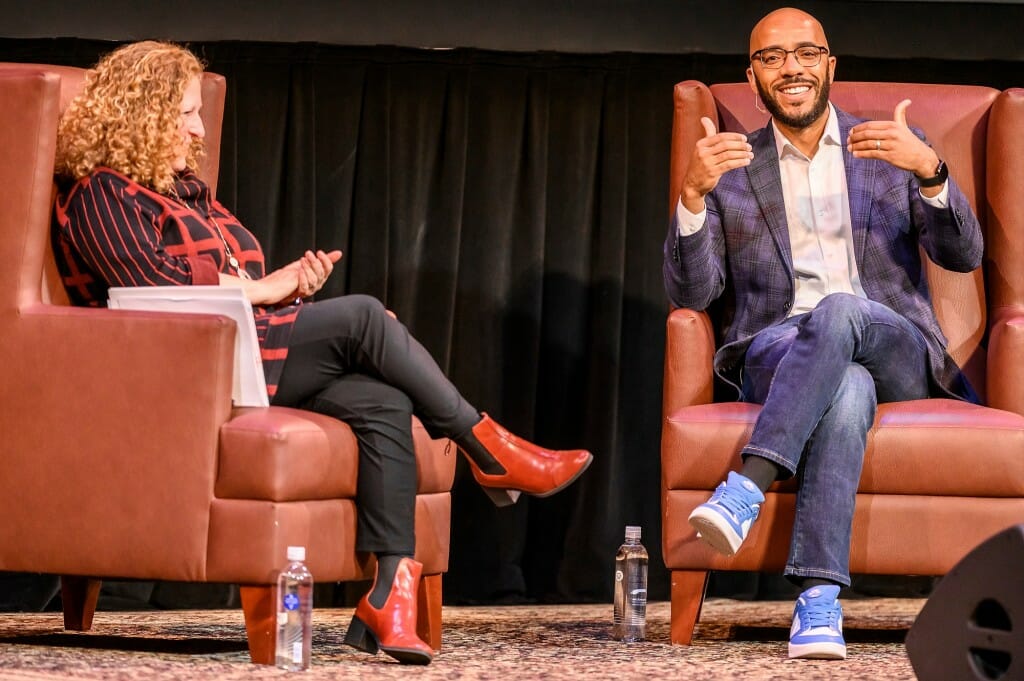 Author Clint Smith gestures while talking to Chancellor Jennifer Mnookin during his talk at Shannon Hall.