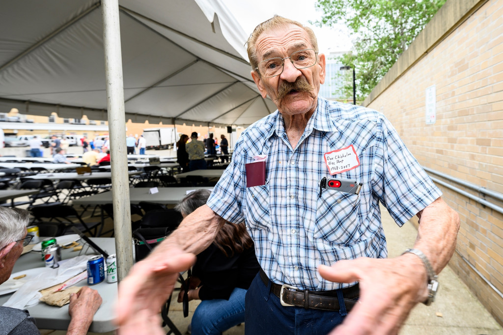 Don Chisholm gestures with both hands as he tells a story to someone off camera.