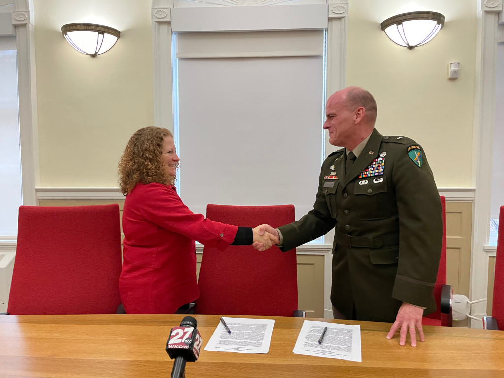 UW–Madison Chancellor Jennifer L. Mnookin and Brigadier General Dean Thompson, 353rd Civil Affairs Command, shake hands after signing an MOU document.