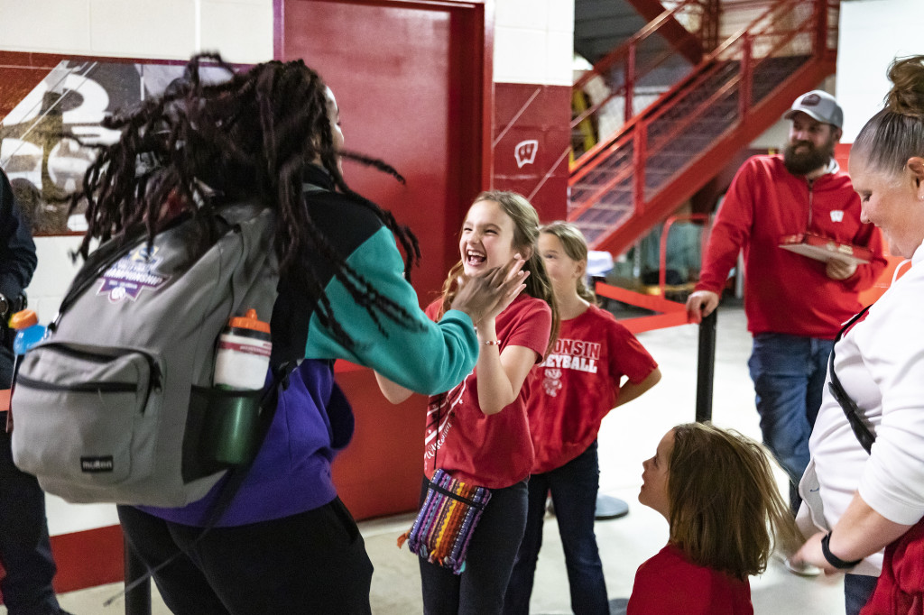 Jade Demps (#15) greets a young fan after the Wisconsin Badgers volleyball team won a match against TCU.