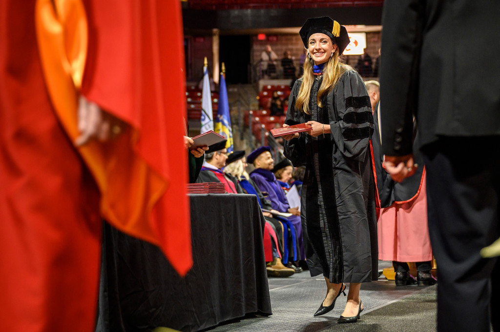 A graduate walks across the stage during the winter commencement ceremony.