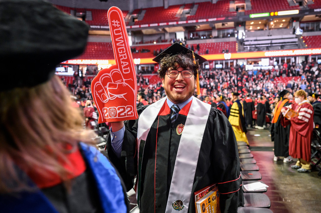 A new graduate celebrates with the help of a foam No. 1 hand.