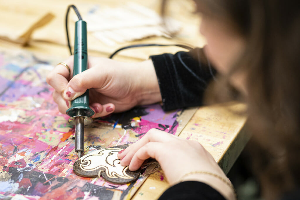 Amalia Sanchez fills in the background of her heart art.