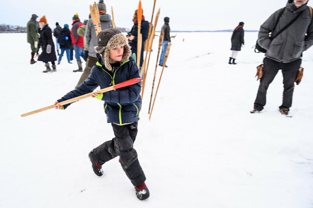 Nine-year-old Emile Pell prepares to throw a snow snake (gooniikaa-ginebig). Snow snakes are carved wooden poles designed to slide well over snow or ice. The purpose of the game is to see who can slide their snow snake the farthest along a specially prepared track.