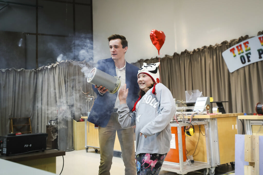 Physics grad student Samuel Kramer (left) helps an audience member shoot a ring of air out of a vortex cannon.