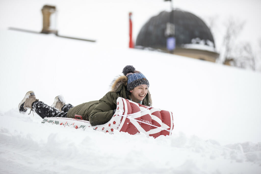 Student Stella Cuene sleds down Observatory Hill near Washburn Observatory.