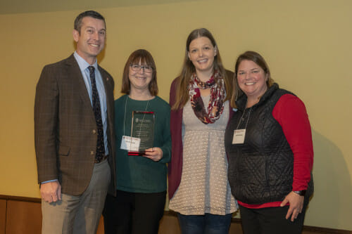 Pictured (L-R): Patrick Sheehan, Paula Gates, Kelly Layton, Ann Bradshaw. The four stand in a row facing the camera and smiling.