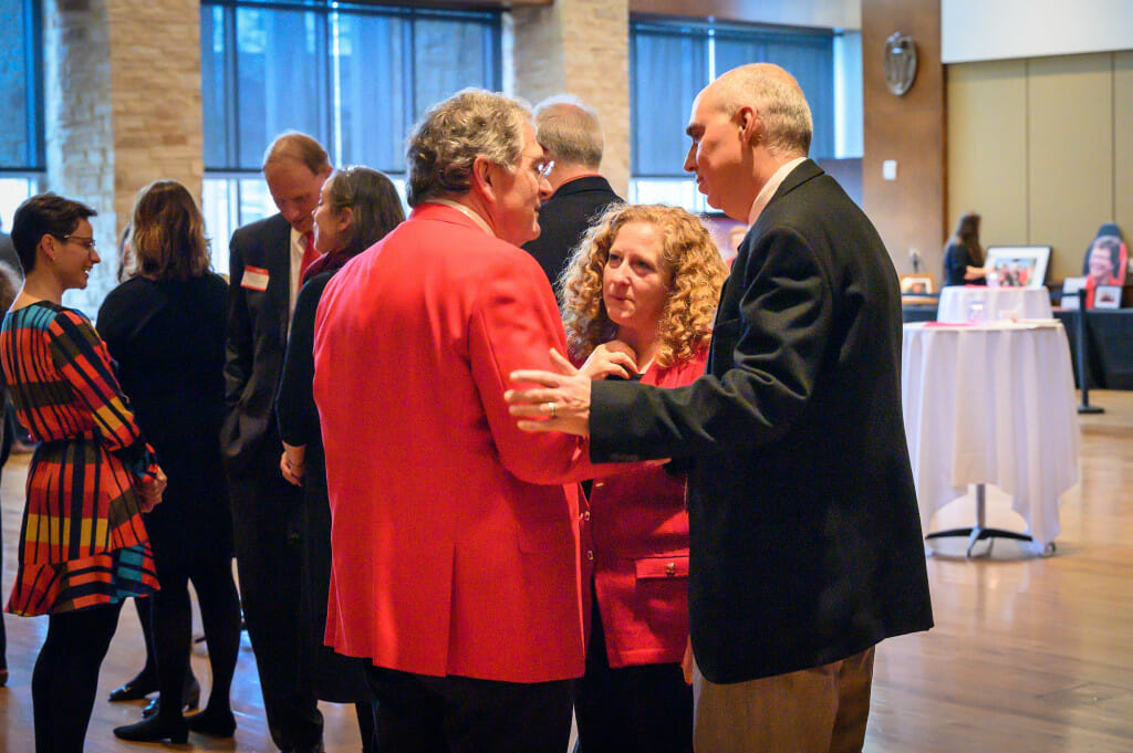 A couple speak with a man, emotional expressions on their faces.