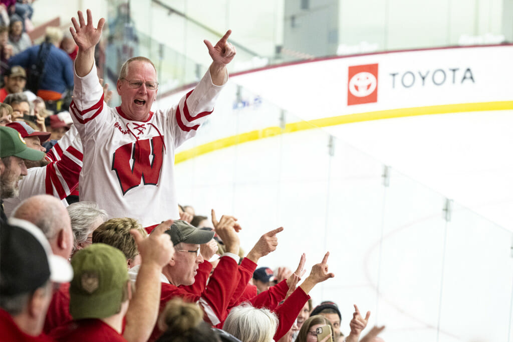 A fan leads the crowd in a cheer counting to seven, the number of national titles held by the team.