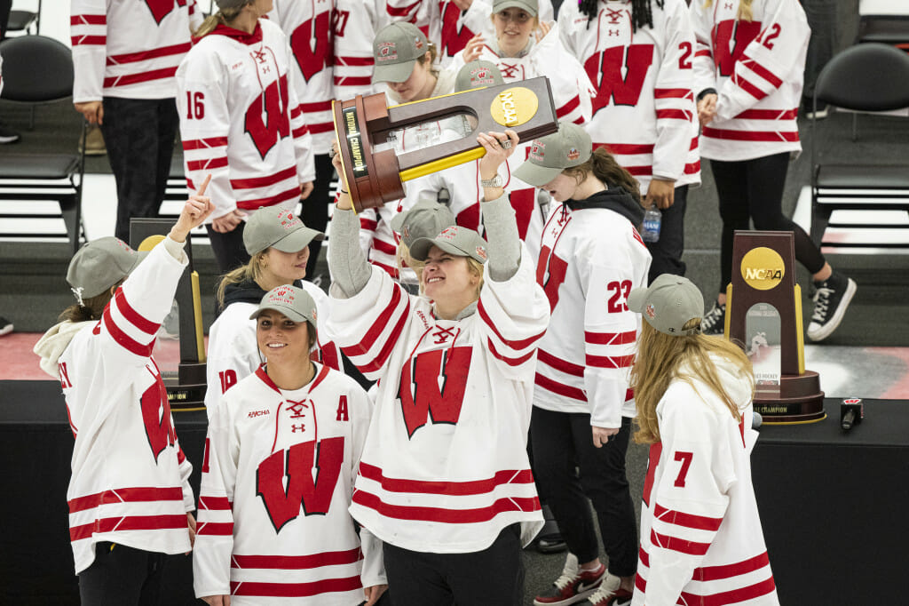 Goalie Cami Kronish raises the championship trophy above her head. 