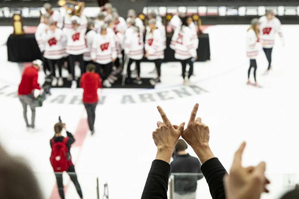 Fans cheer and show the Wisconsin pride with a finger W as the team celebrates its championship.