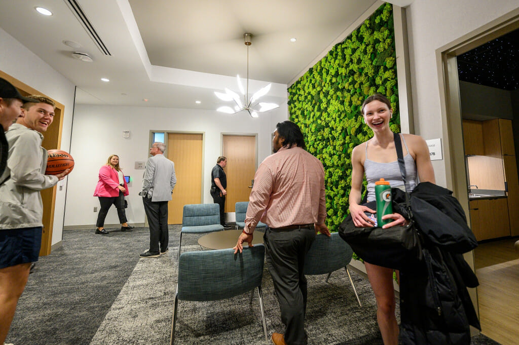 A group of people walk through some wellness rooms, inspecting the equipment.