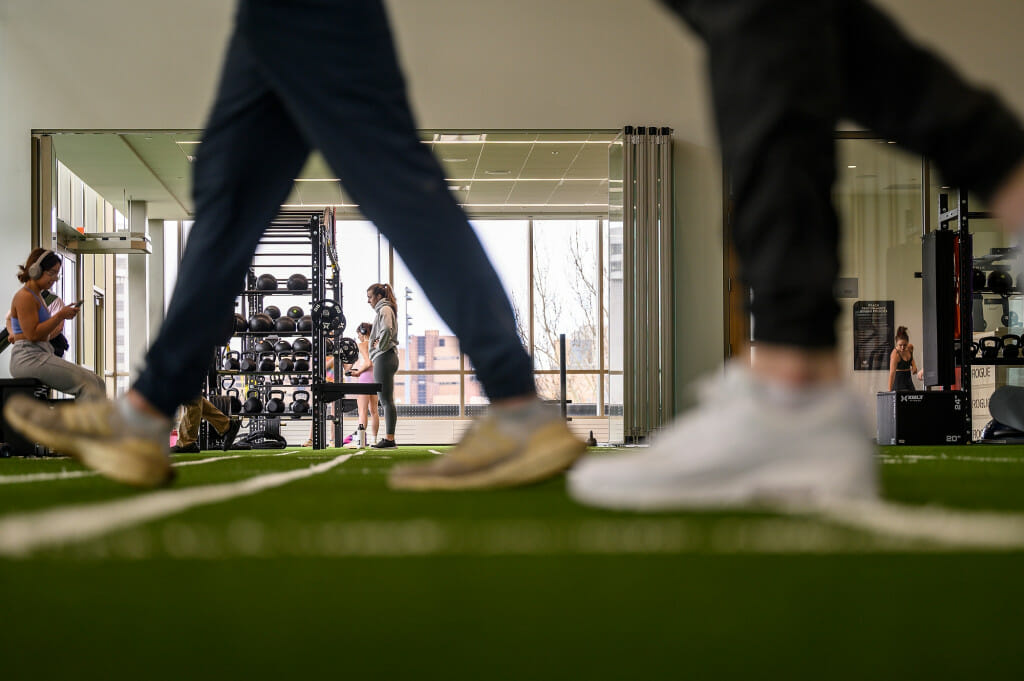 A low view of students' legs as they walk around an exercise area.