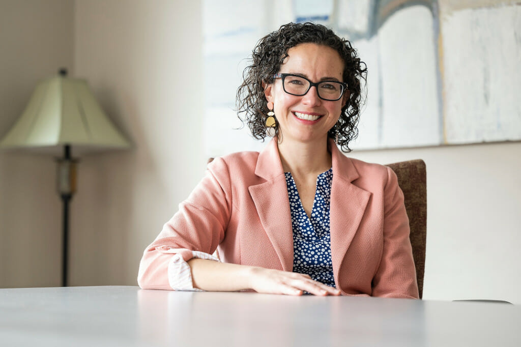 A woman sits at a desk.