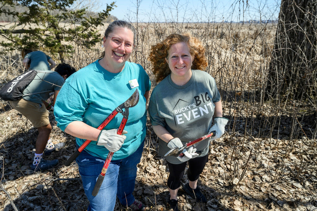 At left, Bryn Scriver, volunteer and outreach coordinator at the Lakeshore Nature Preserve, and Chancellor Mnookin use loppers to remove invasive buckthorn.