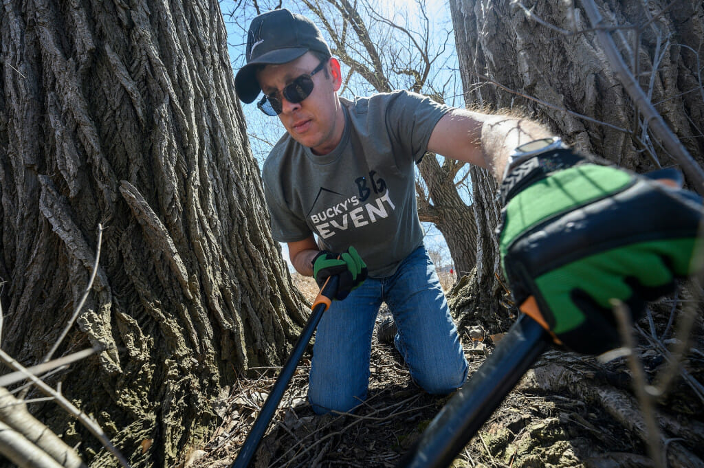 Jay Makowski, MBA ’18 and member of the WAA Alumni Advisory Council, uses a lopper to trim invasive brush.