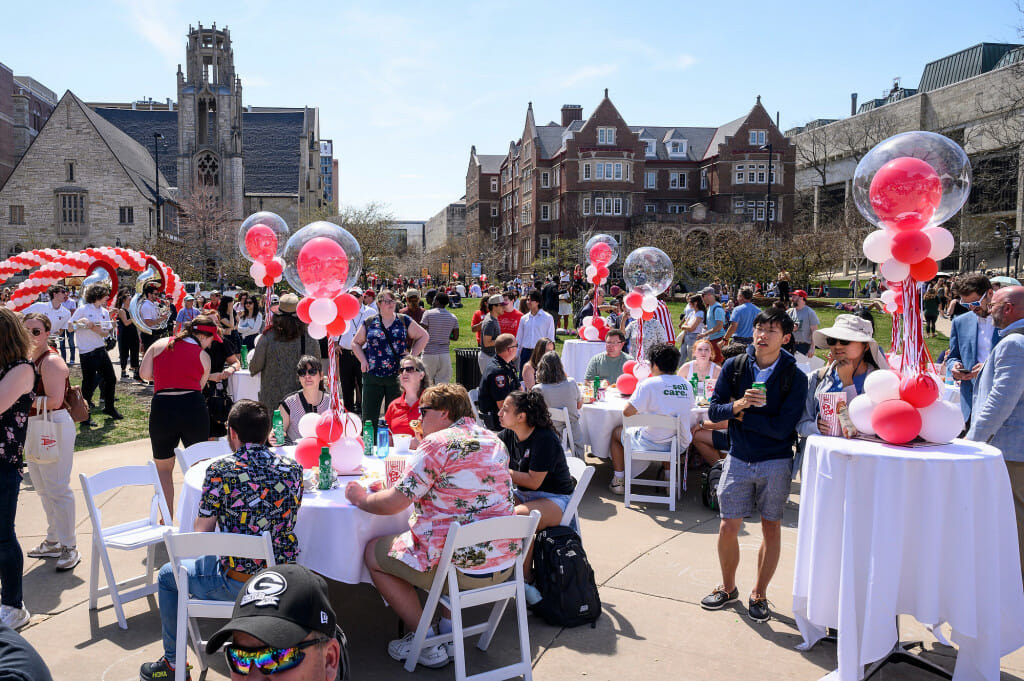 People line up in Library Mall for ice cream, while others relax on the grass and eat ice cream, enjoying the celebration.