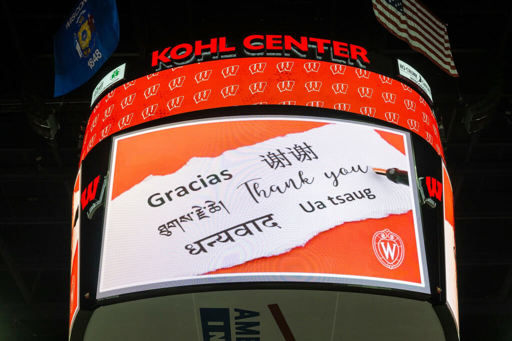 Words of thanks in multiple languages are displayed on the scoreboard at the Kohl Center.