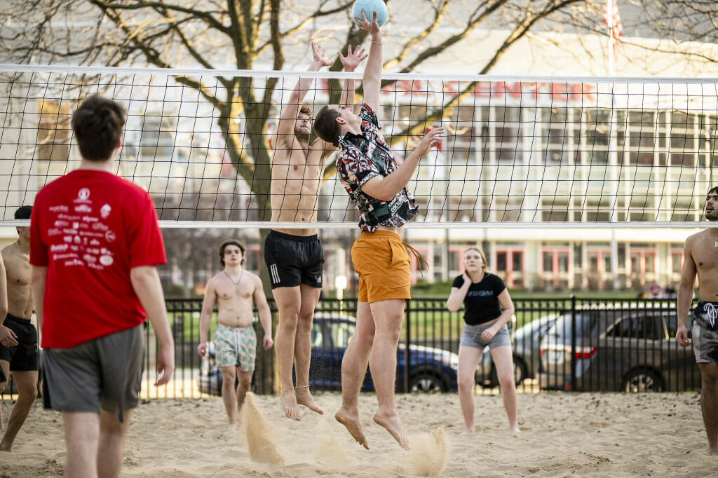 Students play volleyball on the Witte sand court next to the Kohl Center.