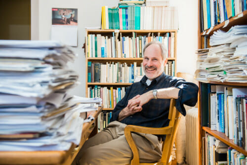 Photo: A man sits at a desk and smiles at the camera.