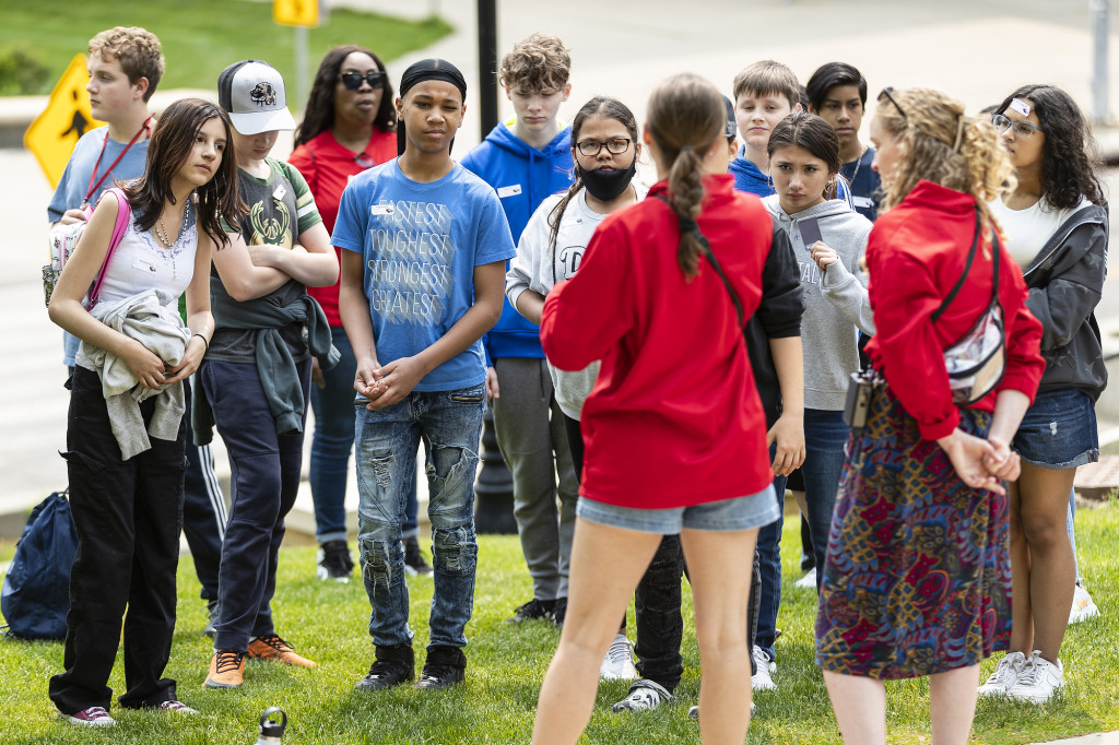 In the foreground are two women turned toward a crowd of kids who face the camera.