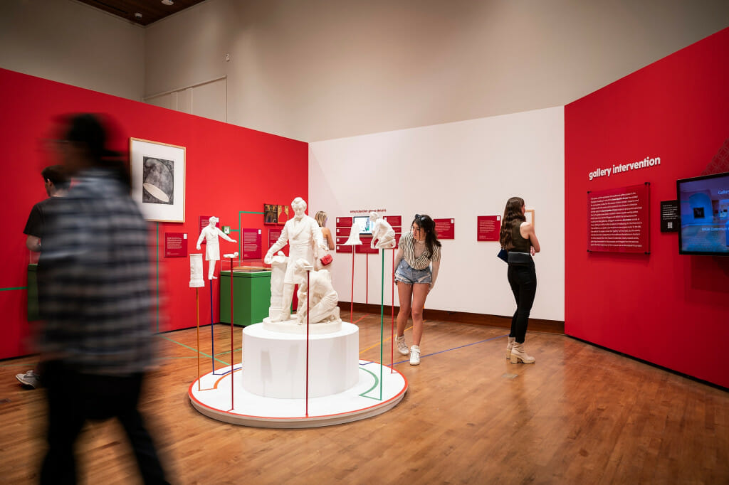 People look at a white marble sculpture.